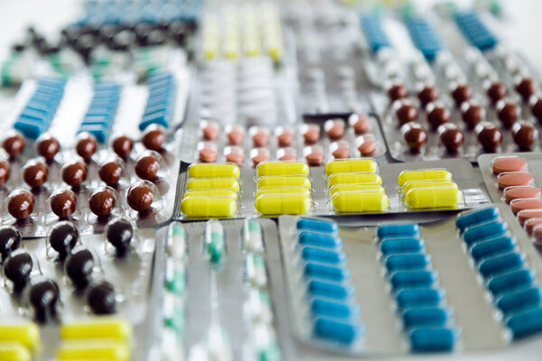Assorted pharmaceutical medicine pills, tablets and capsules on the table.