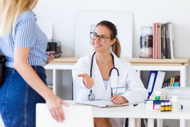 Kadın doktor hastasını ofiste alma.