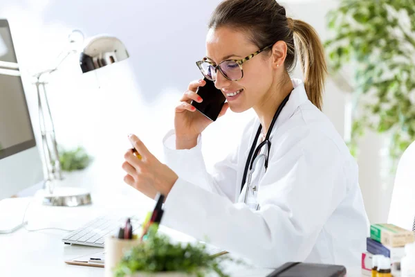 Medico femminile utilizzando il suo telefono cellulare in ufficio . — Foto Stock