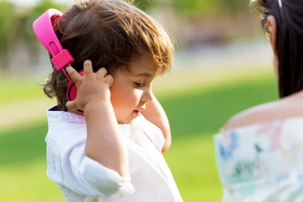 Le petit garçon qui écoute de la musique dans le parc . — Photo