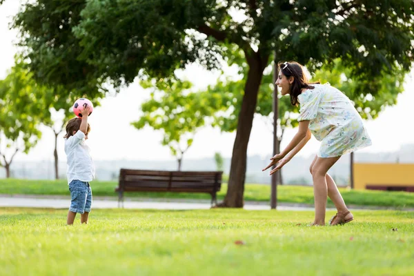 Beautiful young mother with her son having fun in the park. — Stock Photo, Image