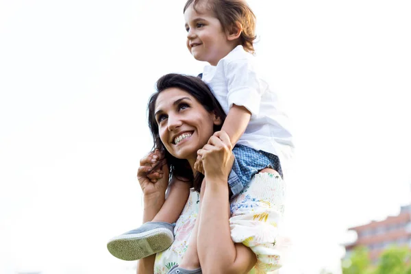 Beautiful young mother with her son having fun in the park. — Stock Photo, Image