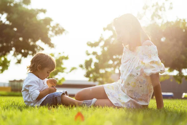 Güzel genç anne oğluyla parkta yoğurt yeme.