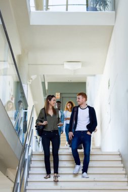 Mutlu genç öğrenci bir üniversitede konuşma grubu.