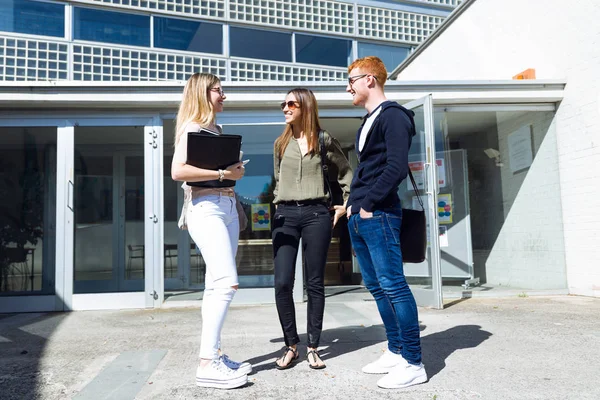 Groupe de jeunes étudiants heureux parlant dans une université . — Photo