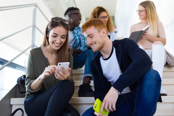 Two students using they mobile phone in a university. — Stock Photo, Image