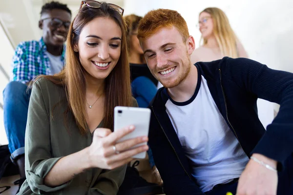 Dois estudantes usando o telefone celular em uma universidade . — Fotografia de Stock