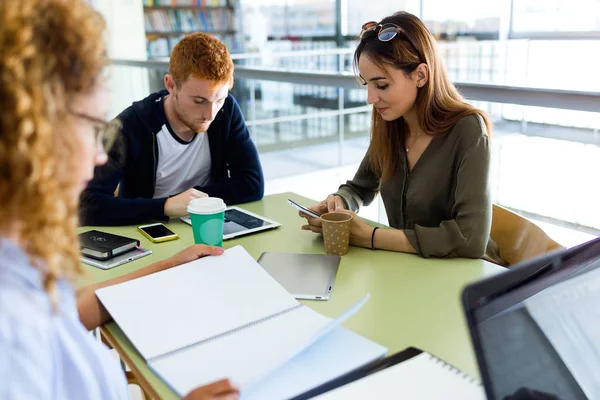 Grupp av vänner som studerar i ett universitetsbibliotek. — Stockfoto