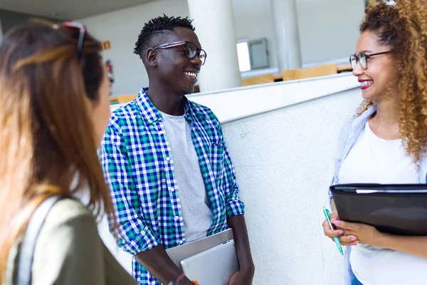 Grupo de jóvenes estudiantes felices hablando en una universidad . — Foto de Stock