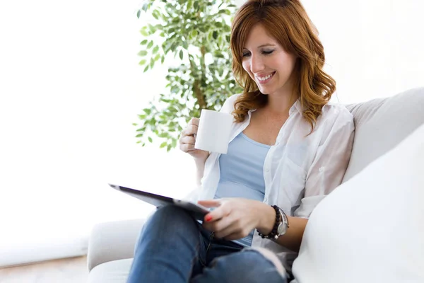Beautiful young woman using her digital tablet at home. — Stock Photo, Image