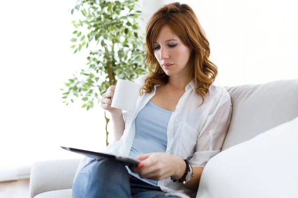 Vacker ung kvinna med sin digitala tablett hemma. — Stockfoto