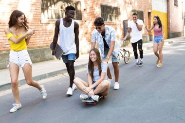 Group of active teenagers making recreational activity in an urban area. clipart