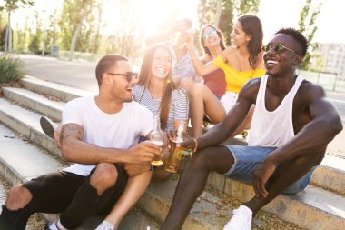 Bir grup genç insan bir kentsel alanda bira ile kızartma.