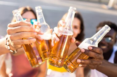 Bir grup genç insan bir kentsel alanda bira ile kızartma.