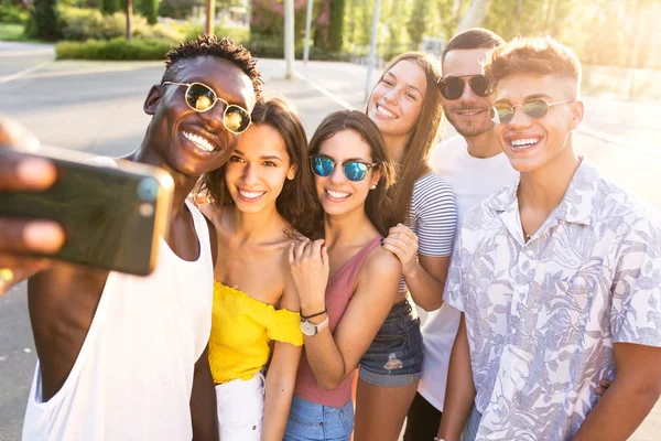 Grupp unga hipster vänner använder smart telefon i ett stadsområde. — Stockfoto