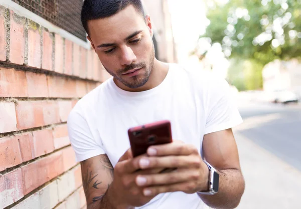英俊的年轻男子在大街上用他的手机. — 图库照片