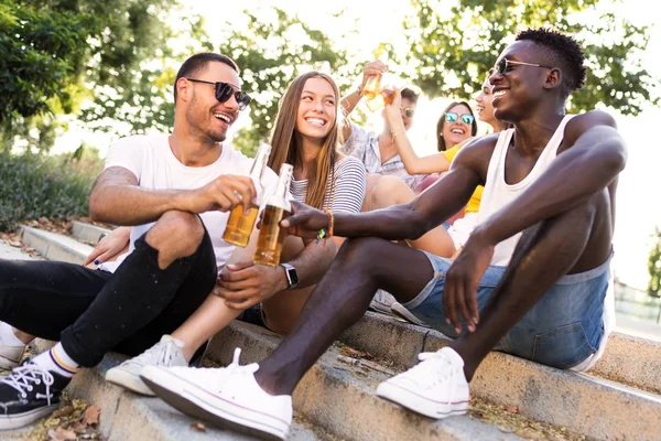 Grupa młodych ludzi opiekania z piwem w obszar miejski. — Zdjęcie stockowe