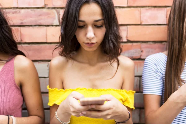 Grupo de jóvenes amigos hipster utilizando el teléfono inteligente en una ciudad son —  Fotos de Stock