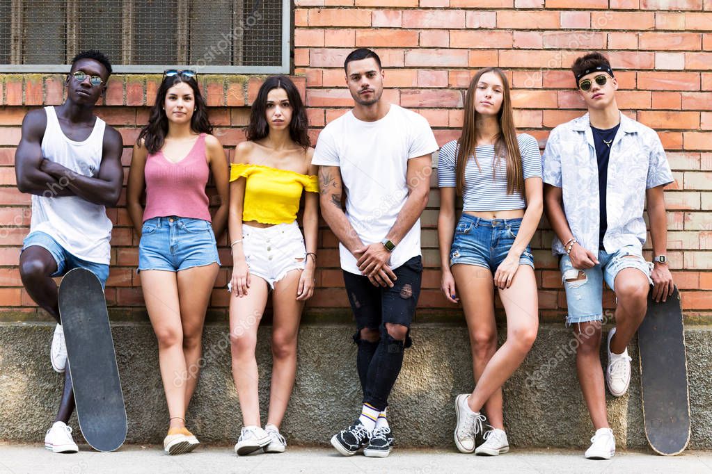 Group of young hipster friends looking at camera in an urban area.