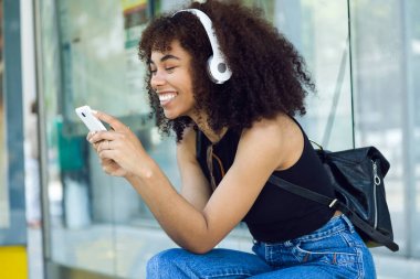Şehir içinde müzik dinlemek güzel genç kadın. 