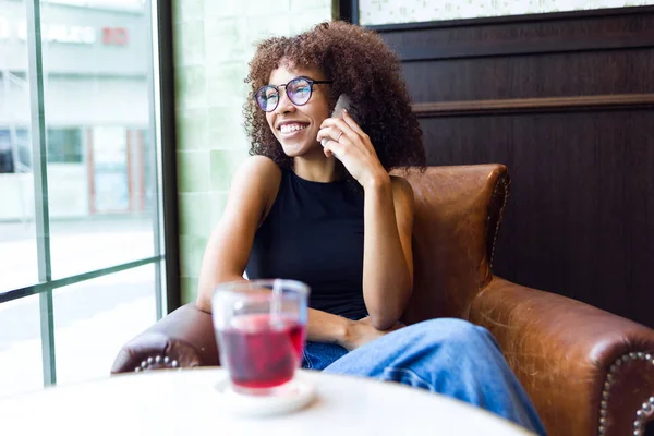 Piękna młoda kobieta za pomocą swojego telefonu komórkowego w kawiarni. — Zdjęcie stockowe