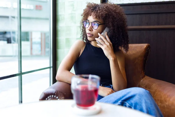 Cep telefonu kafede kullanan güzel genç kadın.