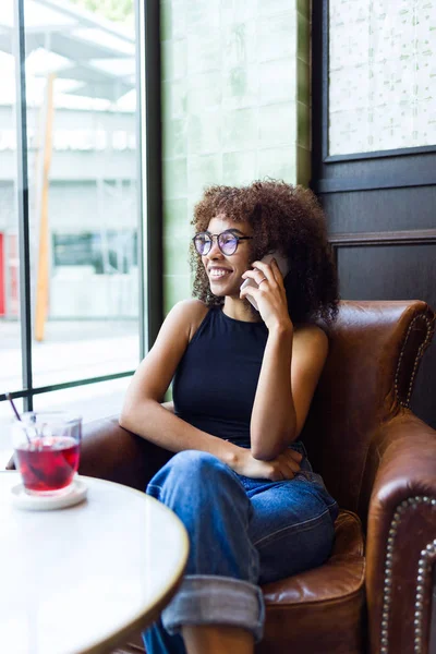 Cep telefonu kafede kullanan güzel genç kadın.