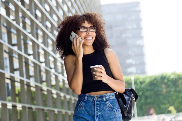 Sokakta cep telefonu kullanan güzel genç kadın.