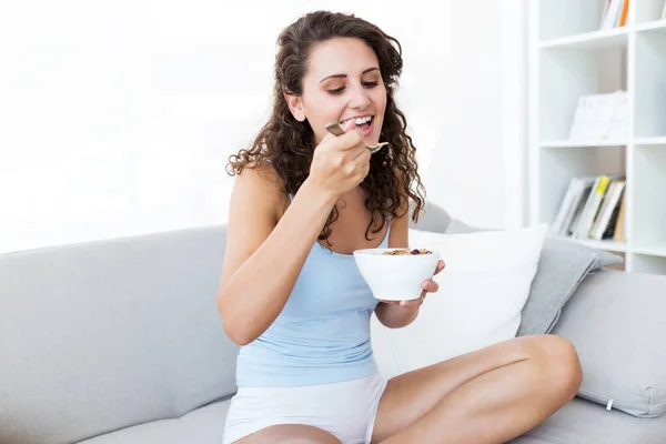 Bella giovane donna mangiare cereali a casa . — Foto Stock