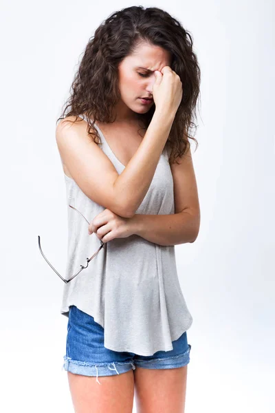 Bella giovane donna che ha mal di testa su sfondo bianco . — Foto Stock