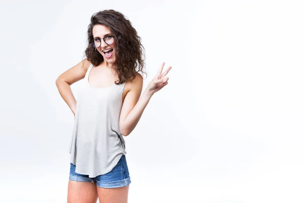 Hermosa mujer joven posando y mirando a la cámara sobre fondo blanco . — Foto de Stock