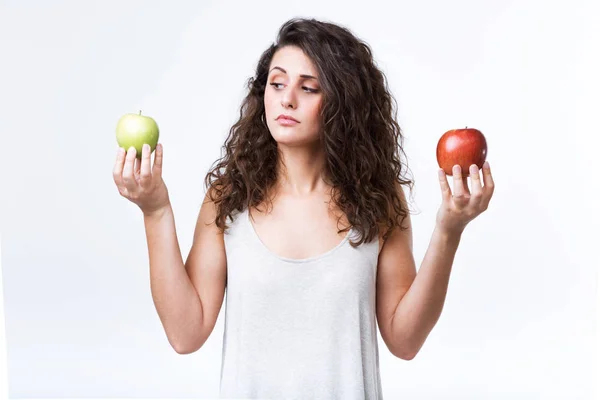 Belle jeune femme tenant des pommes vertes et rouges sur fond blanc . — Photo