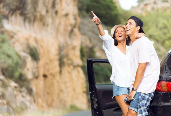 Beautiful young couple pointing away in the mountain. — Stock Photo, Image