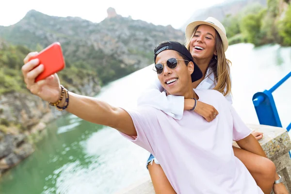 Beautiful young couple taking a selfie in the mountain. — Stock Photo, Image