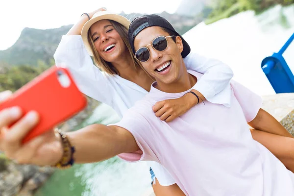 Gyönyörű fiatal pár vesz egy selfie a hegy. — Stock Fotó
