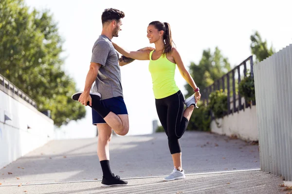 Beau jeune couple s'étirant dans la rue . — Photo