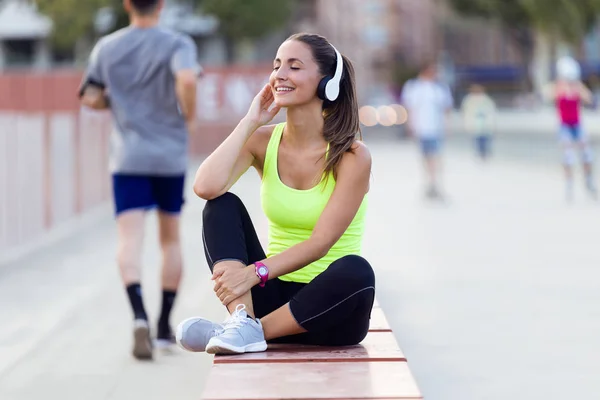 Beautiful young woman listening to music in the street. — Stock Photo, Image