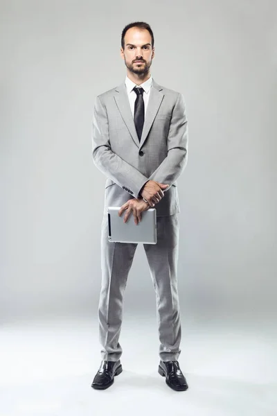 Business young man looking at camera over gray background. — Stock Photo, Image