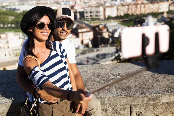 Hermosa pareja joven tomando una selfie en la calle . — Foto de Stock