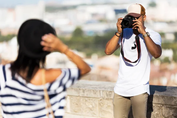 Jovem bonito tirando fotos de sua namorada na rua . — Fotografia de Stock