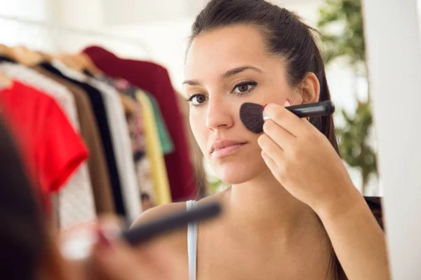 Vacker ung kvinna att göra make-up nära spegeln hemma. — Stockfoto