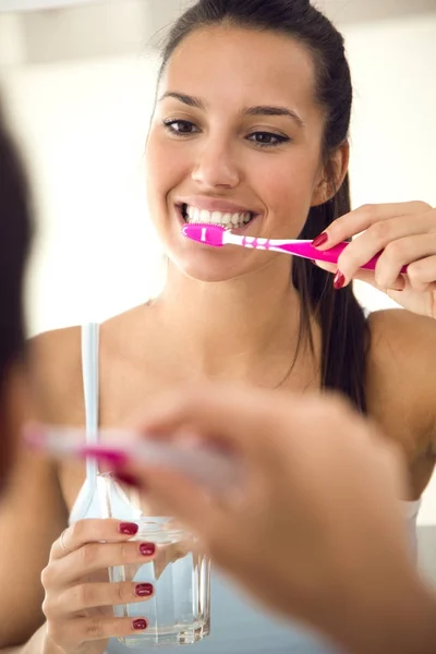 Mooie jonge vrouw haar tandenpoetsen in de badkamer. — Stockfoto