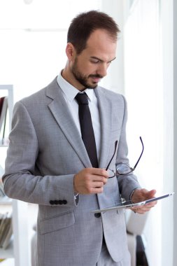 Dijital tablet ofisteki çalımakta yakışıklı genç.