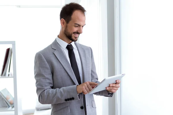 Jovem bonito trabalhando com tablet digital no escritório . — Fotografia de Stock