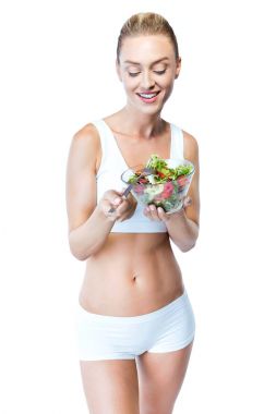 Beyaz arka plan üzerinde salata yemek güzel genç kadın.