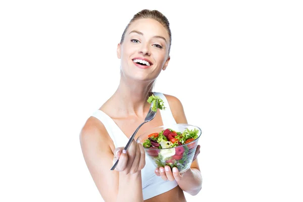 Schöne junge Frau isst Salat über weißem Hintergrund. — Stockfoto