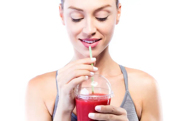 Piękna młoda kobieta pije sok detox z owocami na białym tle. — Zdjęcie stockowe