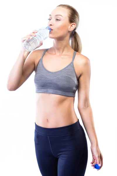 Vacker ung kvinna dricksvatten efter gör övning över vit bakgrund. — Stockfoto