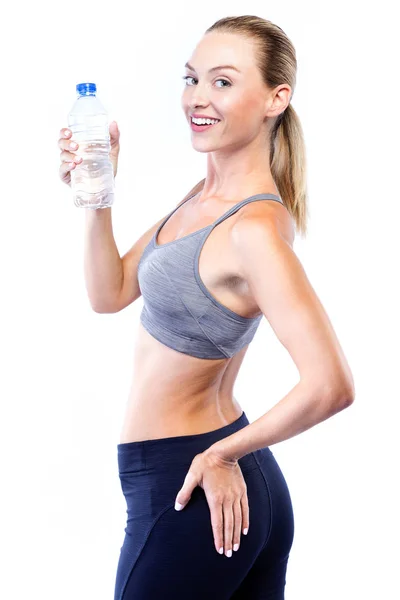 Bella giovane donna che beve acqua dopo aver fatto esercizio su sfondo bianco . — Foto Stock