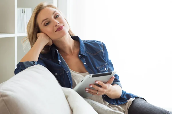 Vacker ung kvinna med sin digitala tablett hemma. — Stockfoto